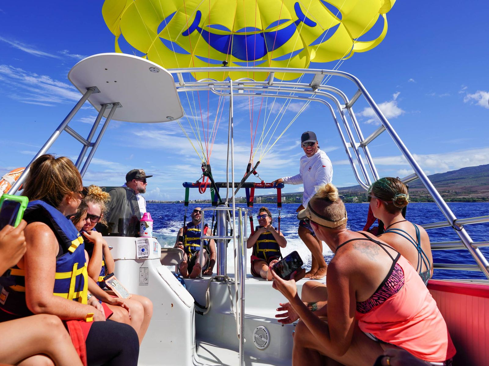 Crew clipping flyers onto the spreader bar on the boat’s flight deck, the yellow smiley canopy already inflated overhead and the rest of the guests watching